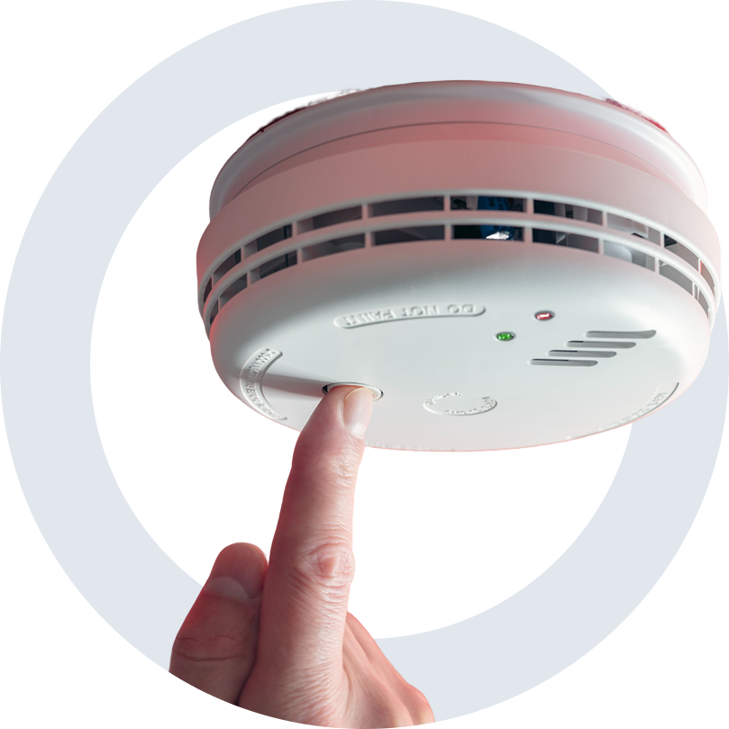 hero A person is touching the smoke detector on their finger.